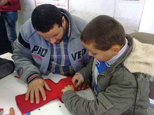 Child and parent during a doll-making activity at a parents’ club