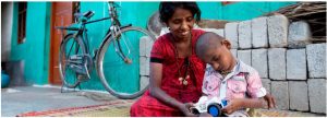 Woman and child sitting on floor. Both holding the same toy car.