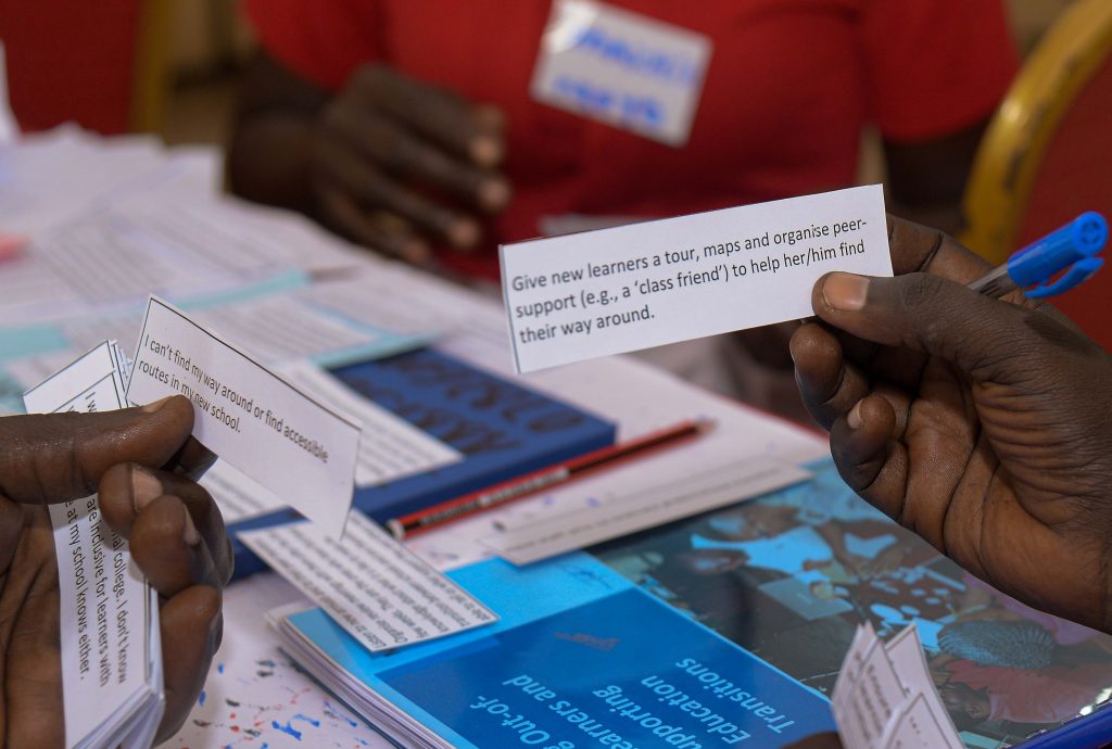 Trainees holding small pieces of paper. One says "Give new learners a tour, maps, organise peer support to help him/her find their way around"