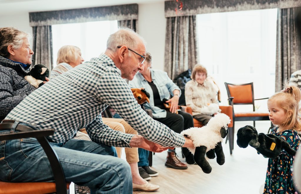 Intergenerational interactions with puppets as part of an early years’ music class.